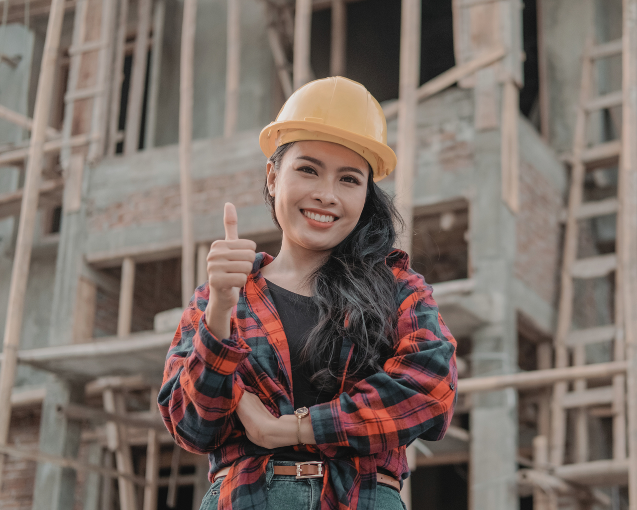 Person mit Schutzhelm auf Baustelle Daumen hoch