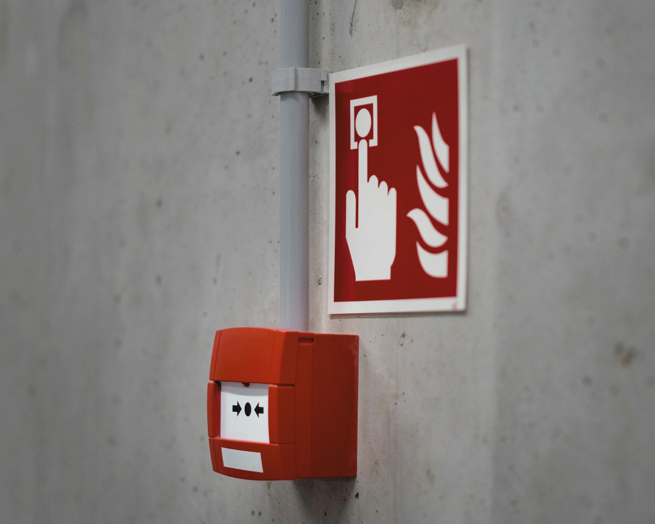 Schild Brandschutz und Feueralarm an Beton-Wand
