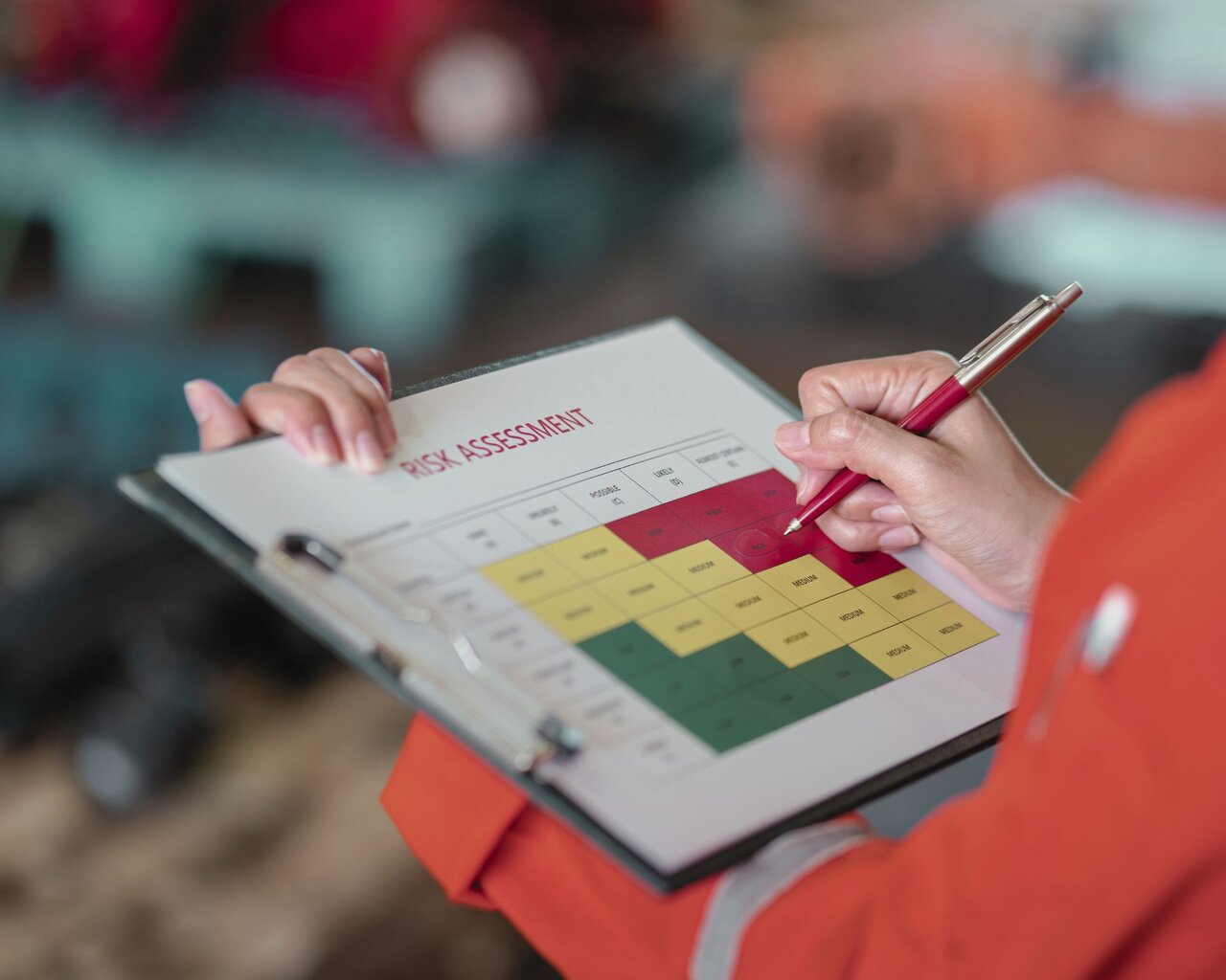 Person hält Klemmbrett mit Grafik zum Risk Assessment
