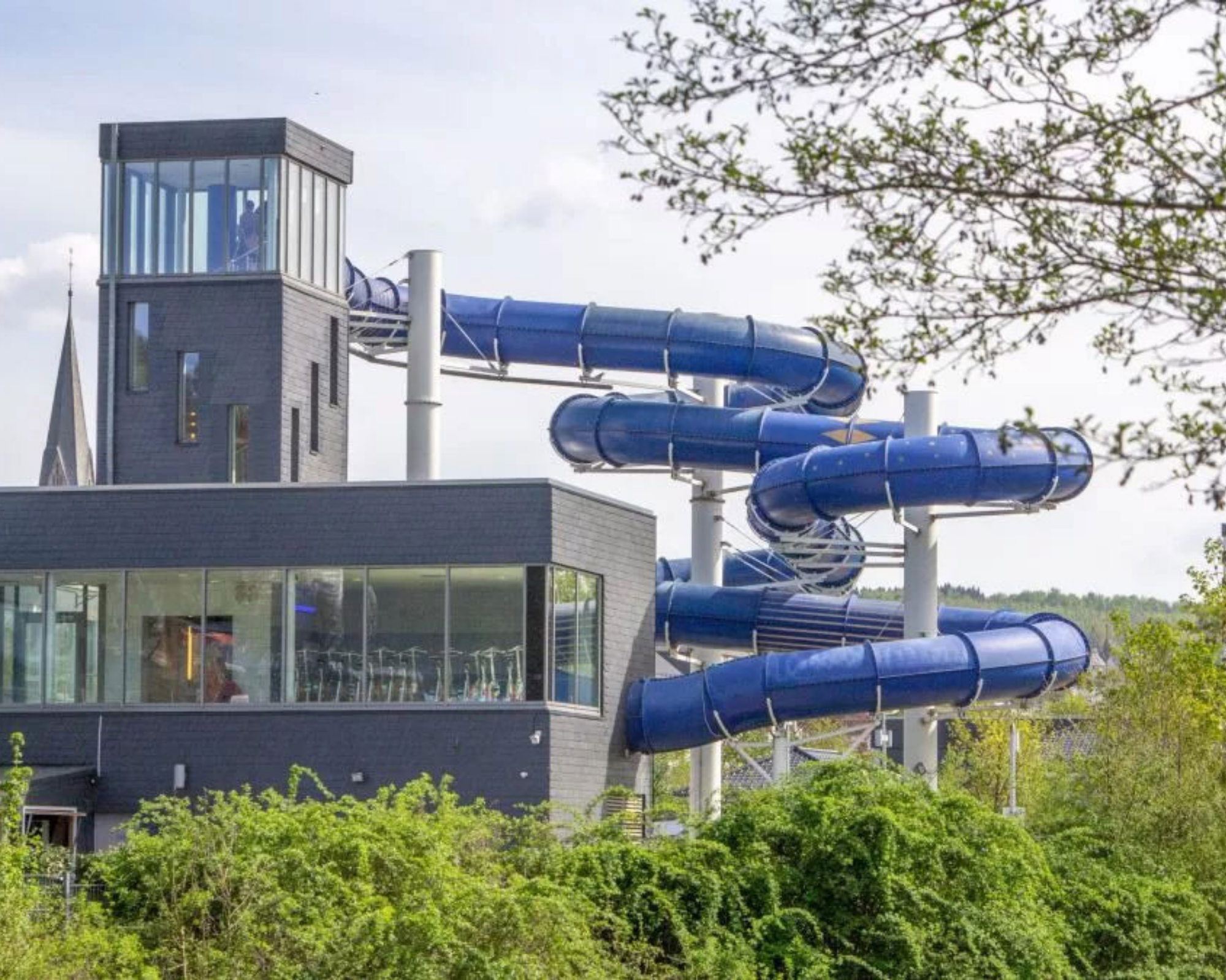 Außenansicht Freizeitbad Olpe mit Wasserrutsche und Begrünung