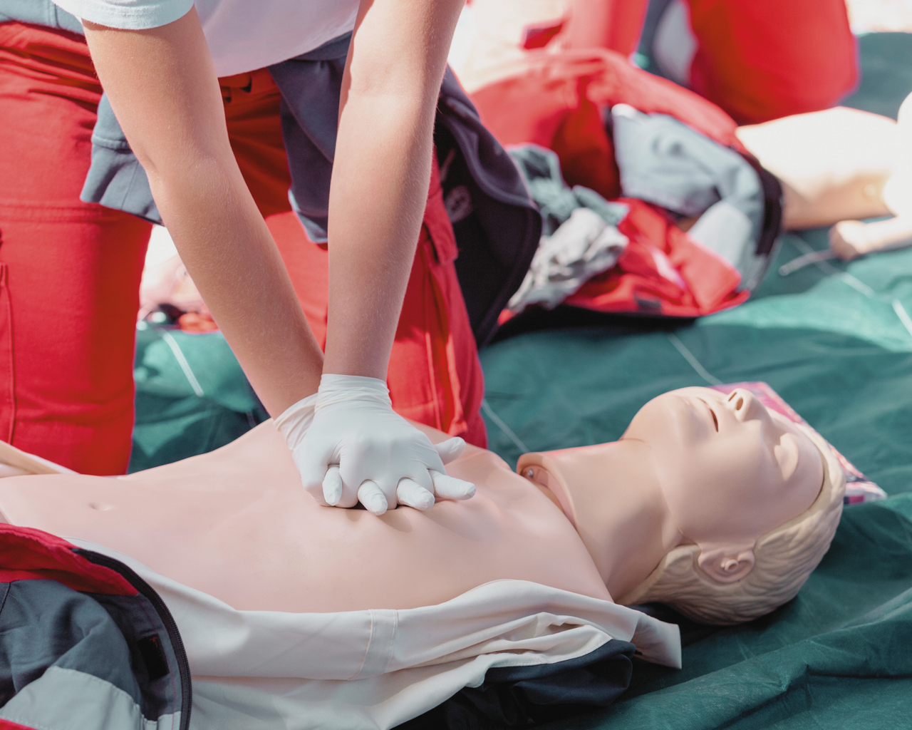 Übung einer Herzdruckmassage an Plastikpuppe